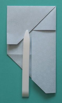 an origami tooth and envelope on a green background