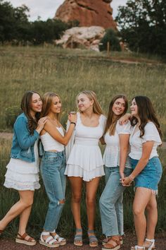 four girls standing together in front of a rock formation