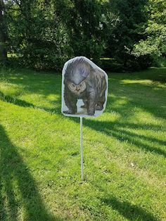 a sign with a bear on it in the grass