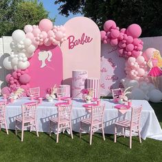 a table set up for a barbie birthday party with pink chairs and balloons on the wall