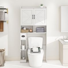 a white toilet sitting in a bathroom next to a shelf filled with towels and other items