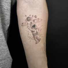 a man with a tattoo on his arm that has an image of a spaceman flying through the sky