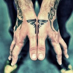 two hands that have tattoos on them