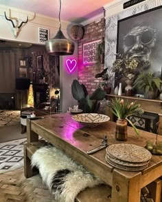 a wooden table sitting inside of a living room next to a fire place and potted plants