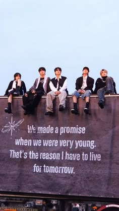 several men sitting on the back of a truck with a message written on it that says, we made a promise when we were very young