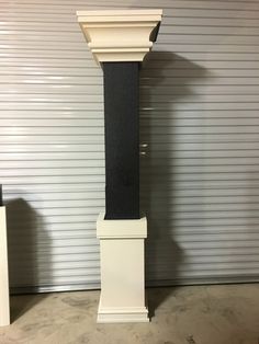 a tall black and white pillar in front of a garage door