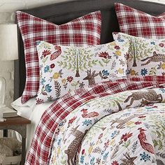 a bed with red and white plaid sheets and pillows