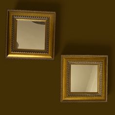 two gold framed mirrors against a brown wall