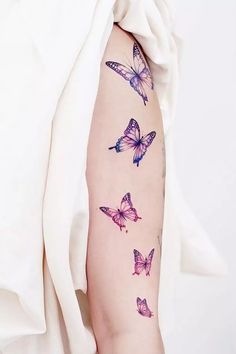 a woman's arm with colorful butterflies on it