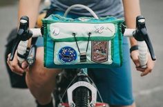 a close up of a person riding a bike with a bag on it's handlebars