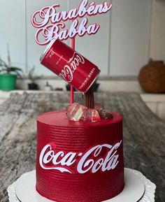 a coca - cola cake is decorated with the word and two cans on top of it