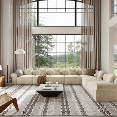 a living room with large windows and beige couches in front of a window that looks out onto the countryside