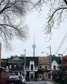 a street with cars parked on the side of it and a tall tower in the background