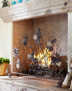 the fireplace is decorated with metal flowers and plants in pots next to it are two potted plants on either side of the fire place