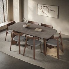 a dining room table with six chairs and a vase on the top, in front of a window