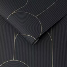 a black and gold patterned wallpaper with circles on the side, in front of a dark background