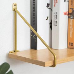 a book shelf with books and a plant on it