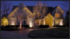 a house lit up at night with lights on the front and side of the house