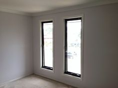 an empty room with two windows in it