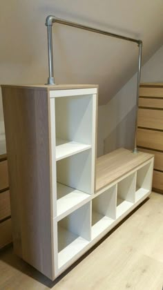 an empty shelf in the corner of a room with wooden flooring and white walls