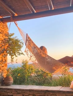 a woman laying in a hammock on top of a stone wall