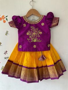 Traditional Kanchipuram silk skirt and raw silk top - yellow pavadai with maggam work purple top. BUYER'S PLEASE LEAVE YOUR CONTACT NUMBER. It's necessary for shipping. Leave message in the buyer note about the age of kid . Fabric and Work: Top: . Fabric used  is raw silk and is embellished with maggam work. The dress is lined with soft cotton fabric. The top has hook opening at back side of the dress. Skirt: Kanchipuram silk fabric with purple jacquard boarder and also lined with a cotton fabric to give comfort for your little one. The skirt has tie at waist line, If you need petticoat skirt we will customize it for you. Your little girl feels comfortable wearing this dress as it has a cotton lining for both top and skirt . It's a light weight soft Kanchipuram silk . If you need any custo Pattu Pavadai Kids Blouse Designs, Pattu Pavadai Designs, Pattu Pavadai, Kids Dress Collection, Kids Blouse Designs, Kids Lehenga, Kids Blouse, Kids Dress Patterns, Baby Dress Design