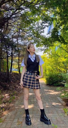 a girl in a school uniform standing on a path