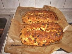 two loaves of bread sitting on top of brown paper