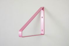 a pink triangle shaped object on a white wall