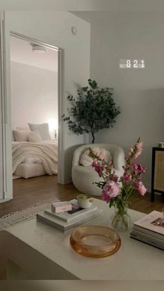 a living room filled with furniture and flowers on top of a coffee table in front of a mirror