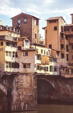 buildings on the side of a river next to a bridge