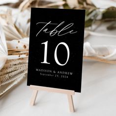 a table number sign sitting on top of a wooden easel