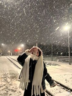 a woman standing on train tracks in the snow