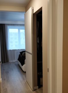 an open door leading to a bedroom with a bed in the corner and closet behind it