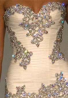 a white dress with lots of crystal stones on the bust and bottom, is displayed in an instagram