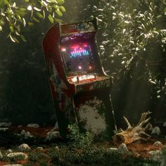 an old video game sitting in the middle of some rocks and grass with trees behind it