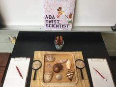 there is a wooden tray with some food on it and two pens in front of it