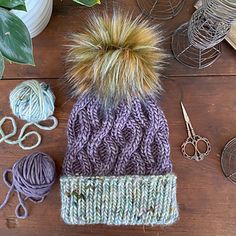 a knitted hat with two different colored yarns next to it