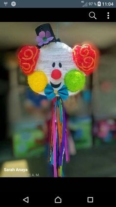 a close up of a mobile with a clown face on it