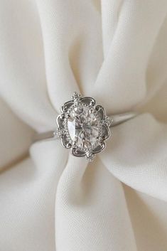 a diamond ring sitting on top of a white cloth