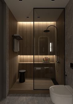 a bathroom with a toilet, sink and shower in it's center wall is illuminated by recessed lighting