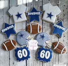 decorated cookies arranged in the shape of footballs, helmets and stars on a wooden table