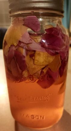 a jar filled with flowers sitting on top of a table