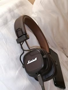 headphones resting on top of a bed with the name marshall written on it's side