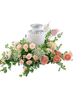 an arrangement of flowers and a candle on a white background