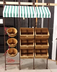 several wooden boxes are stacked on top of each other in front of a green and white awning