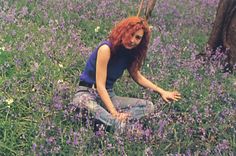 a woman sitting in a field of purple flowers