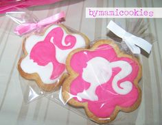 two pink and white decorated cookies in plastic bags