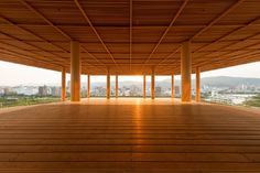 an empty room with wooden floors and large windows overlooking the cityscape in the distance