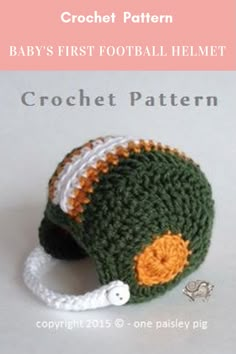 a crochet football helmet with an orange and white ball on it's side